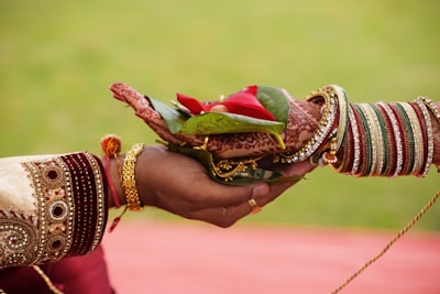 person holding bouquet of red roses indian teams background