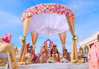 people sitting on chair under red and white floral umbrella