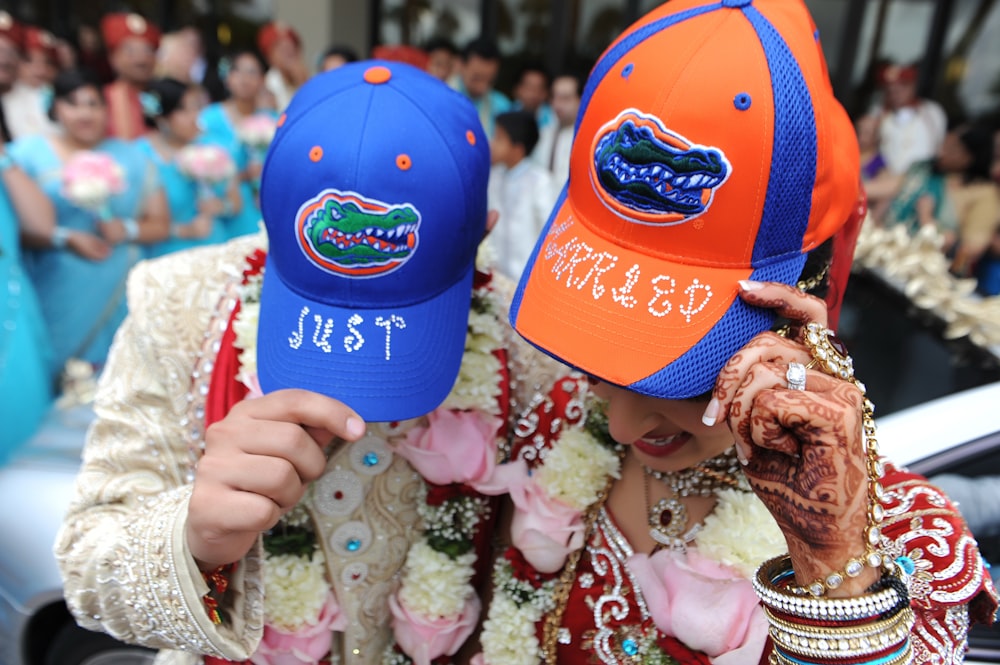 person holding blue and orange cap