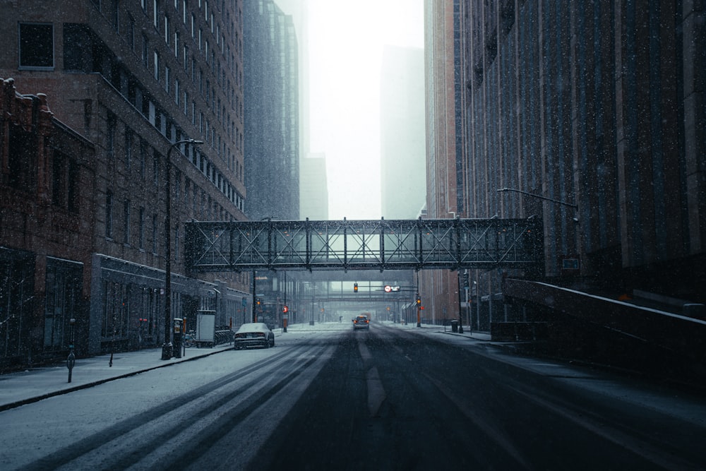 black car on road between high rise buildings during daytime