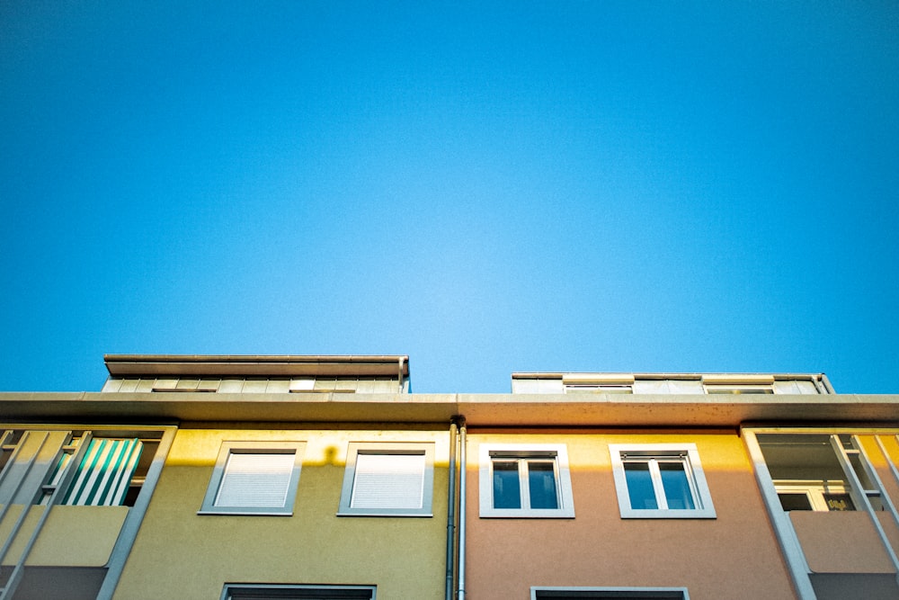 blau-weißes Betongebäude tagsüber unter blauem Himmel