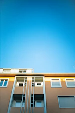 Close-up of a smooth, freshly painted commercial building facade under clear sky.