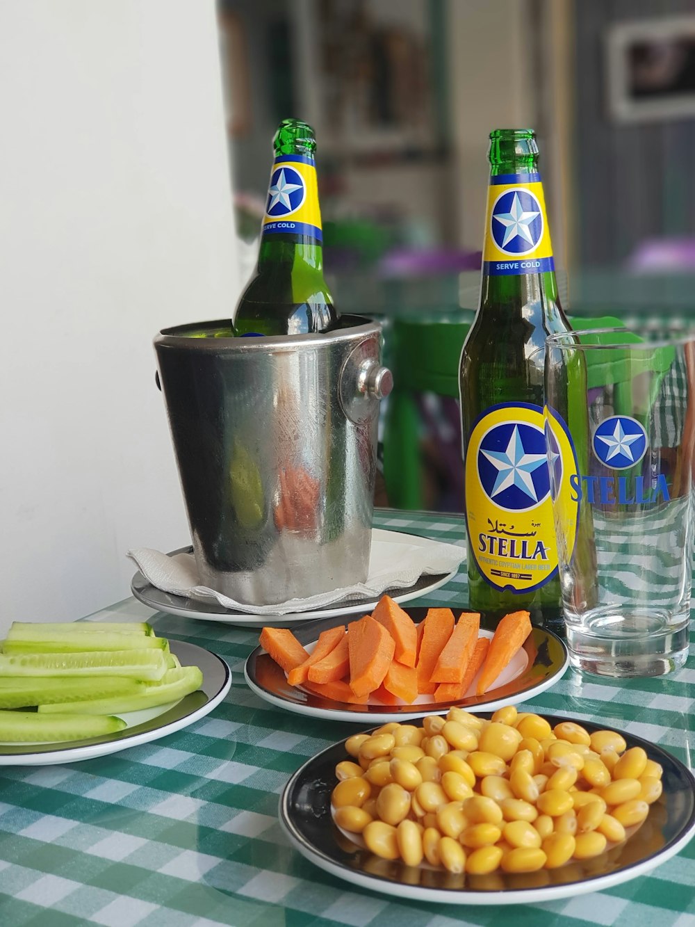 green glass bottle beside stainless steel bucket