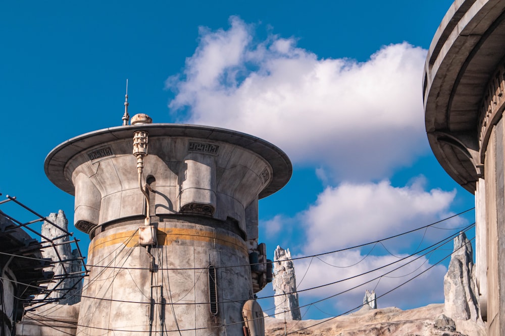 gray concrete water tank under blue sky and white clouds during daytime
