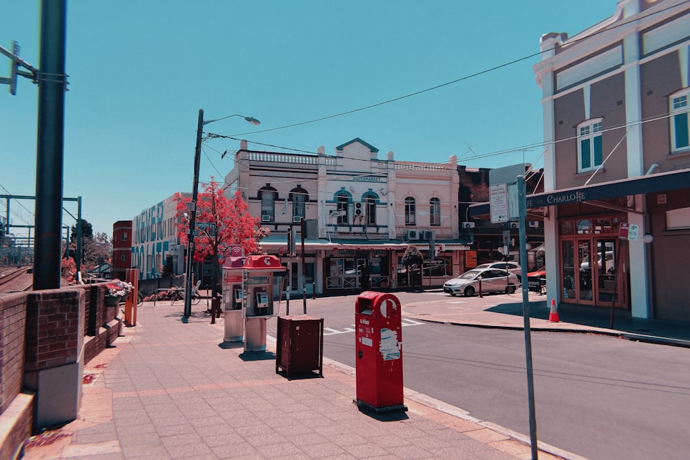 red trash bins on sidewalk during daytime