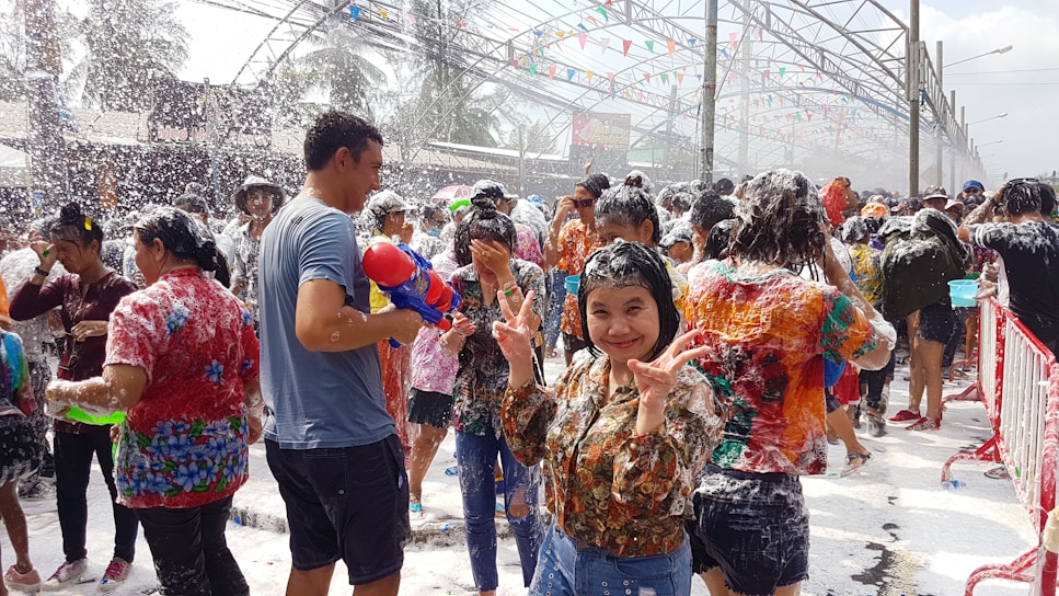 Colorful foam cannon spraying bubbles at a lively outdoor party.