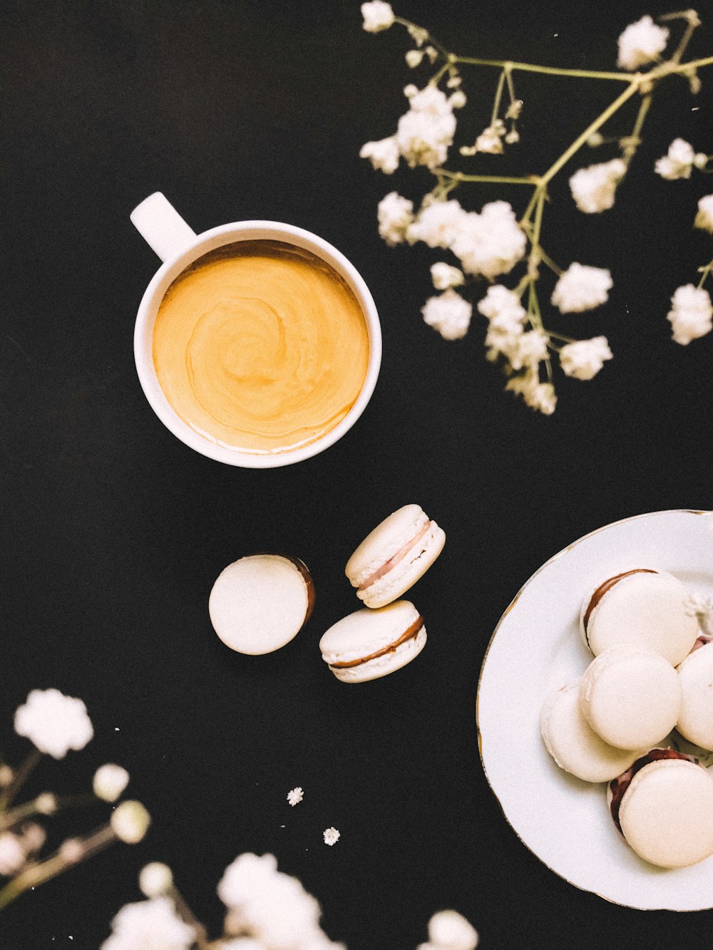 white ceramic mug with coffee on white ceramic saucer