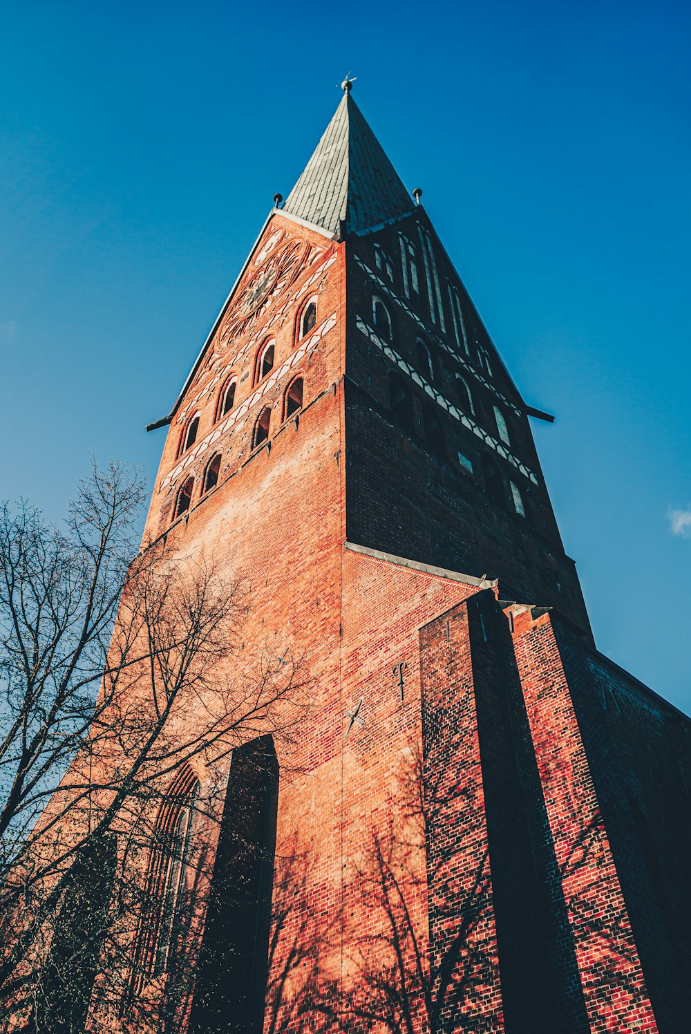 a very tall brick tower with a clock on it's side