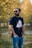A casual outdoor scene featuring a man wearing a stylish t-shirt in a park.