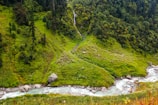 A lush green valley with a winding river cutting through the terrain.