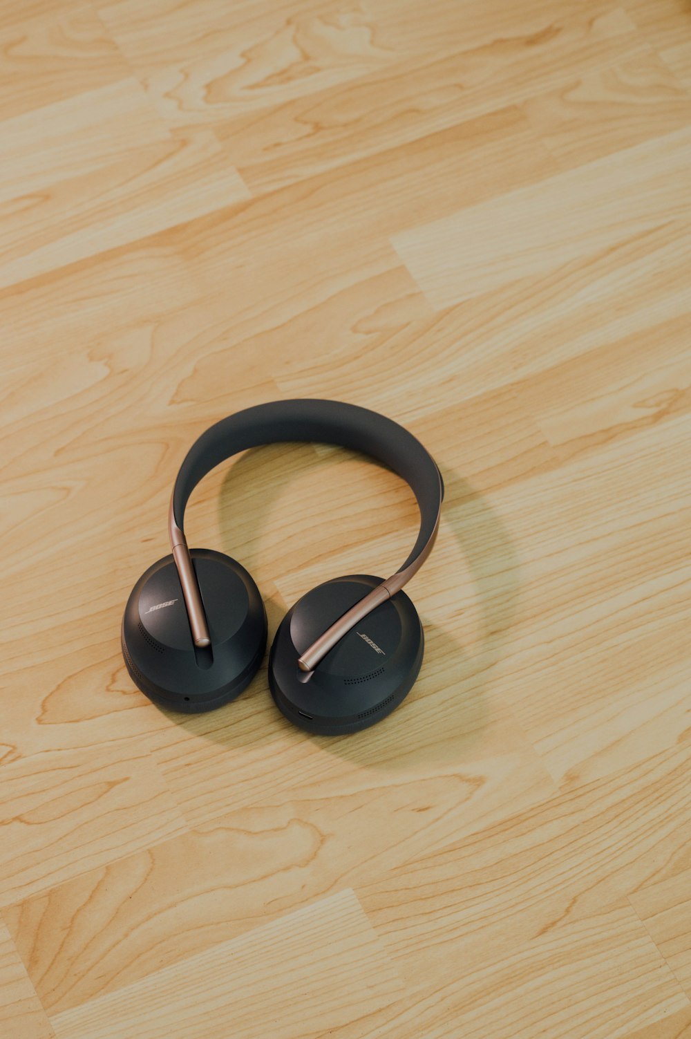 black wireless headphones on brown wooden floor