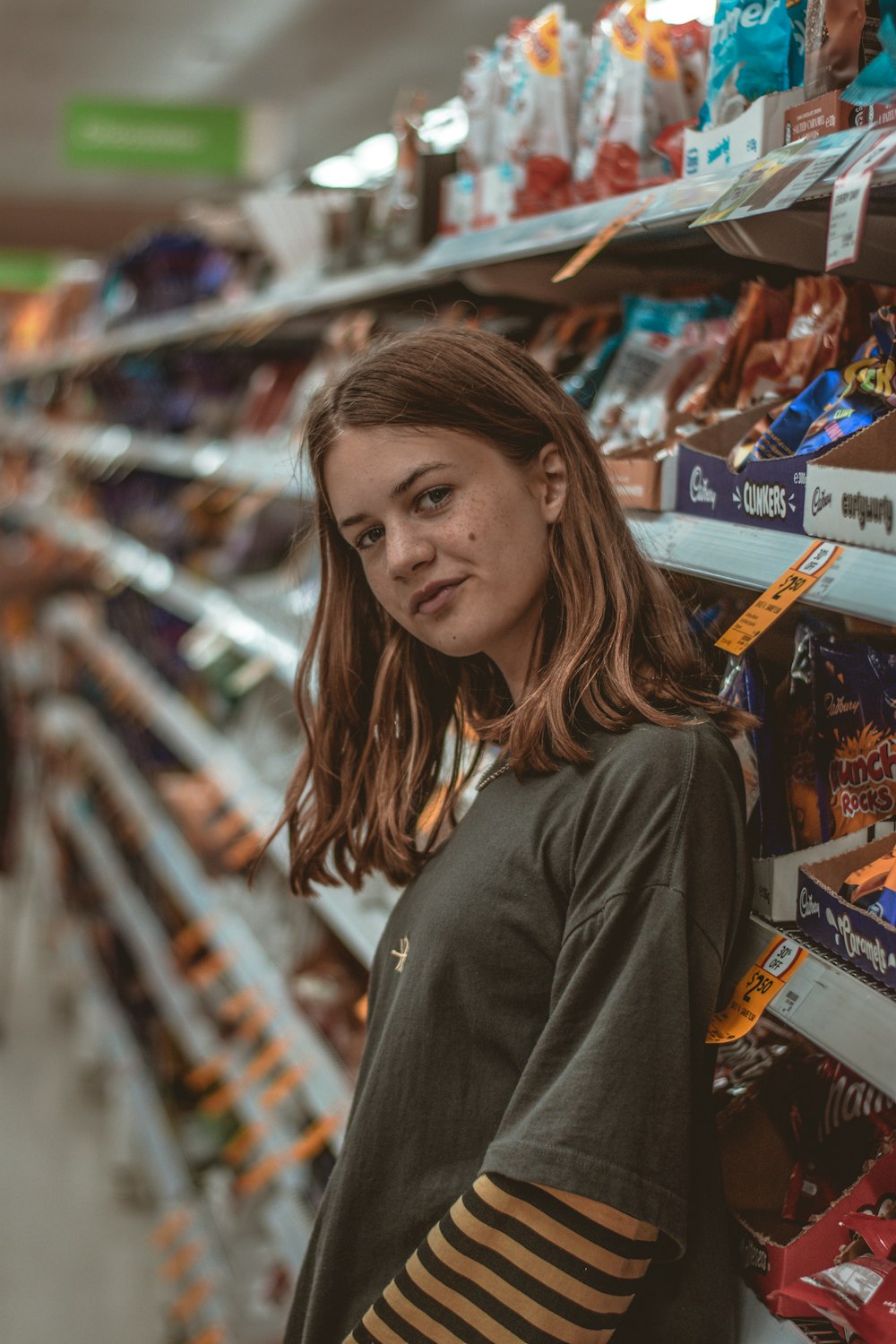 woman in gray long sleeve shirt standing near assorted plastic packs