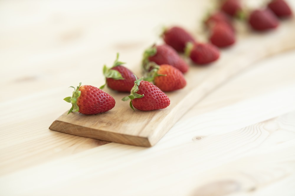 red strawberries on brown wooden chopping board