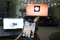 A joyful player interacting with a mobile trivia game in a cozy living room.