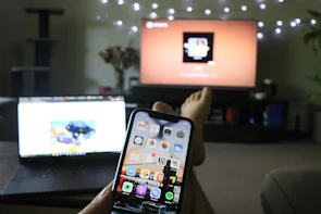 A modern smartphone streaming Wplay Premium TV app in a cozy living room.