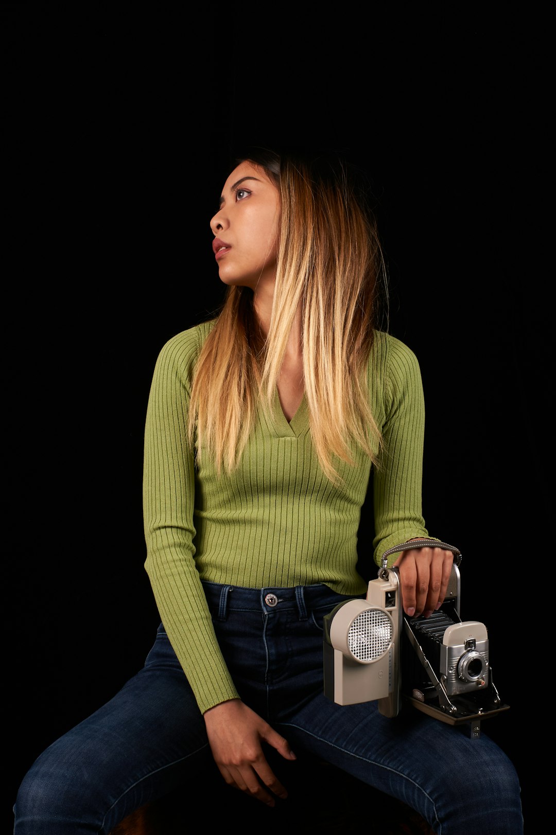 woman in green long sleeve shirt holding camera