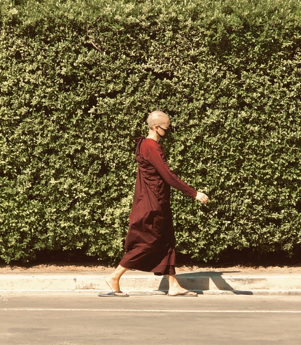 woman in red long sleeve dress standing on brown concrete floor during daytime