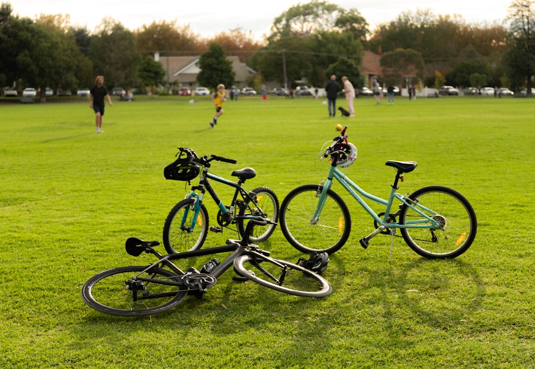 green and black mountain bike on green grass field during daytime