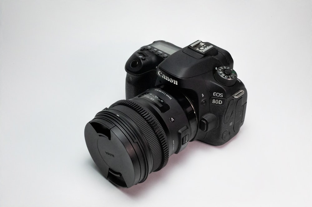 black nikon dslr camera on white surface