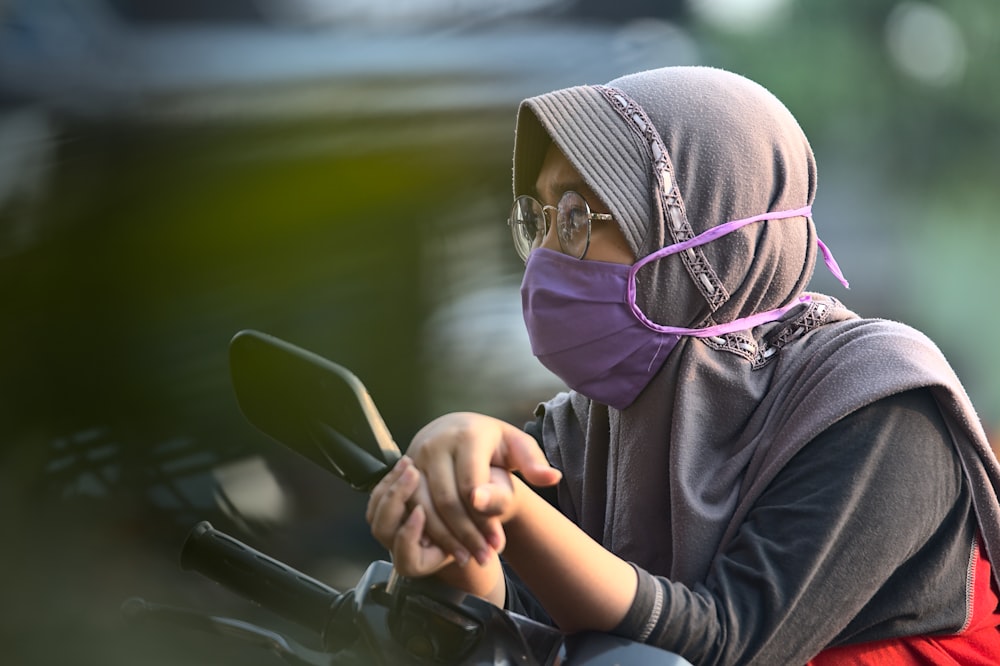 woman in black hoodie wearing purple hijab