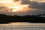 A sunset with dark clouds over a peaceful Thai riverside town.