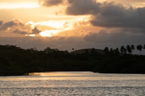 A sunset with dark clouds over a peaceful Thai riverside town.