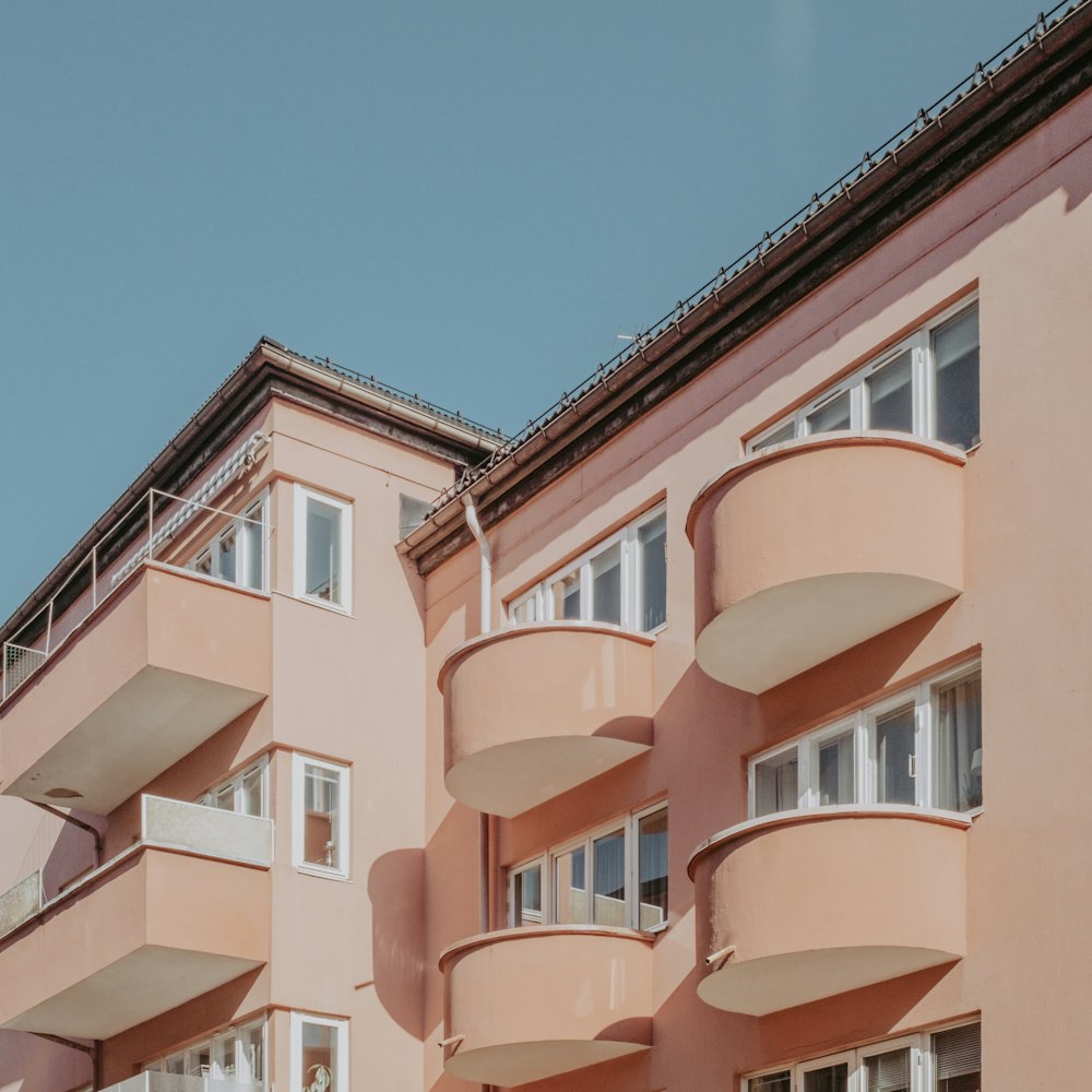 Edificio de hormigón marrón y blanco bajo el cielo azul durante el día