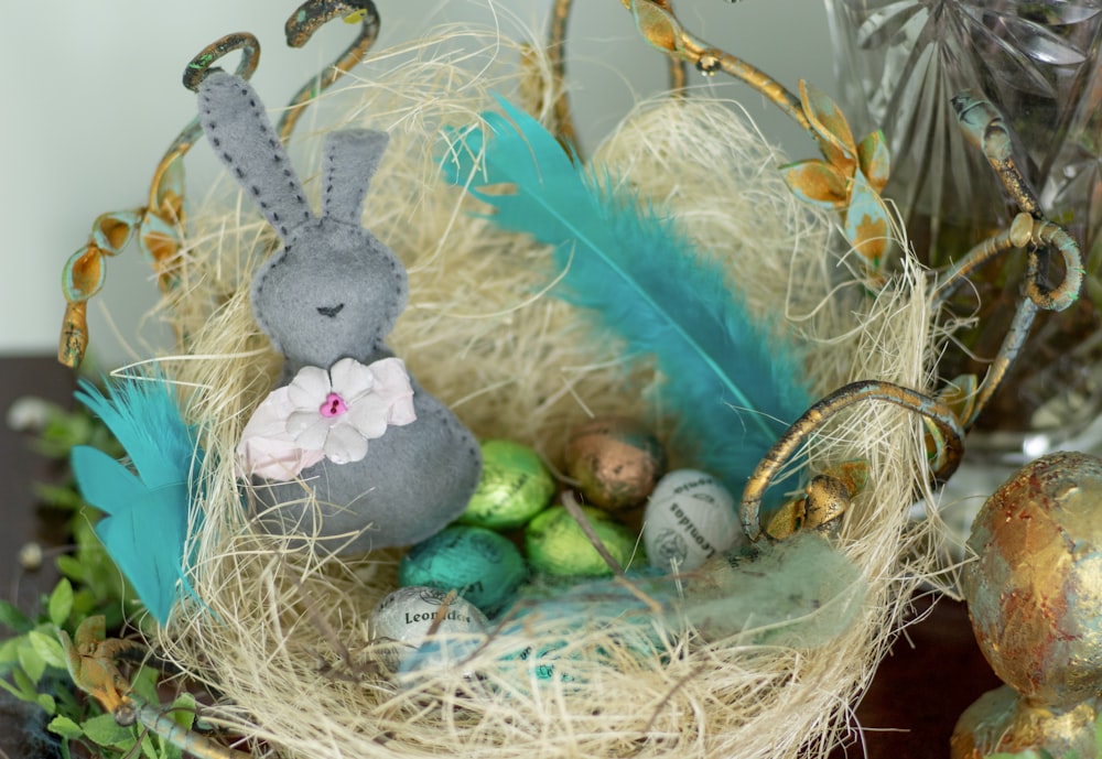 gray rabbit plush toy on brown nest