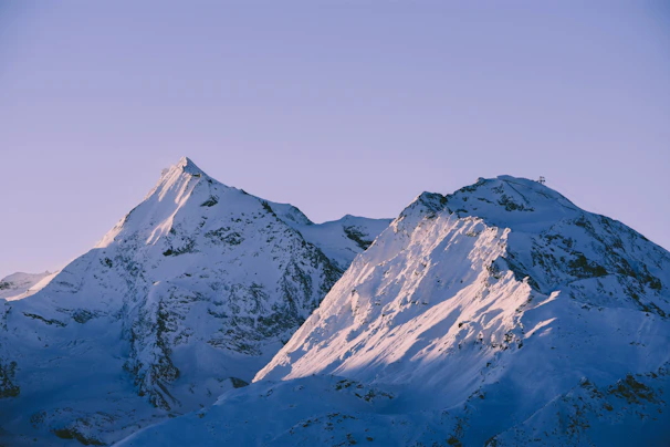 The serene snowy white peaks of Adi Kailash towering over the tranquil landscape at dusk.