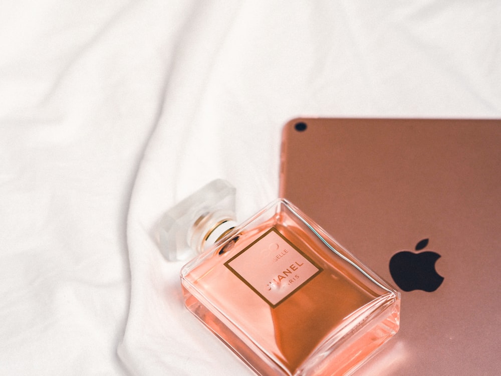 clear glass perfume bottle on white textile