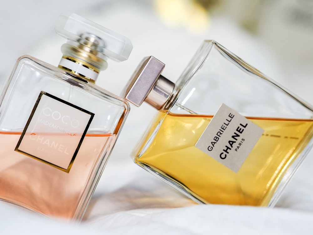 a couple of bottles of perfume sitting on top of a bed