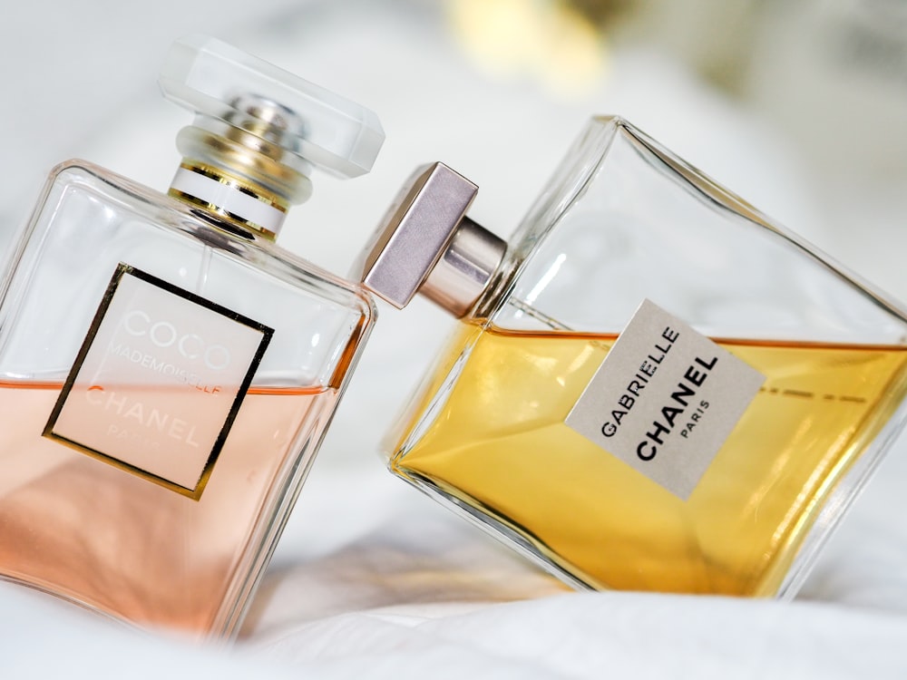 quelques flacons de parfum posés sur un lit