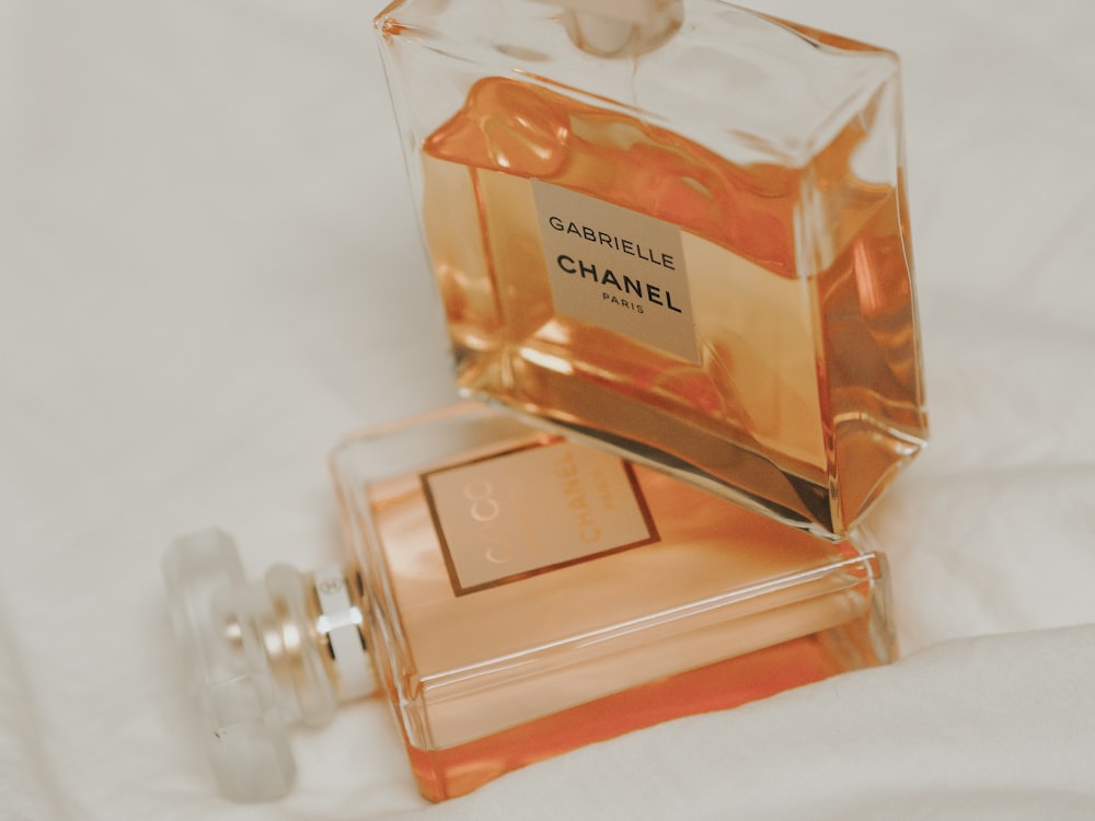 clear glass perfume bottle on white surface