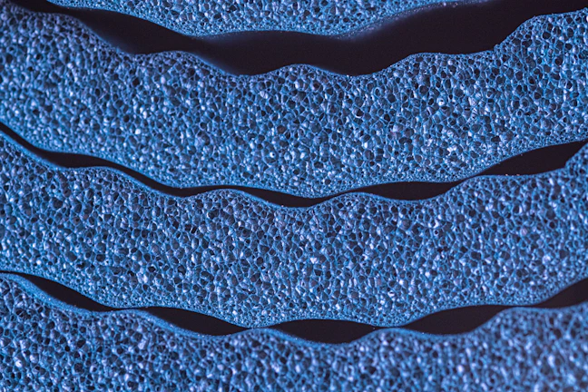 Close-up of depth filtration membrane texture with elegant 3D pore structures and aqua highlights