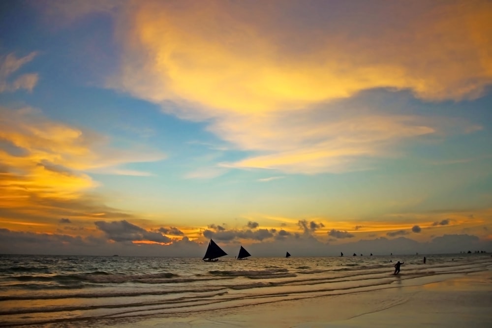 silhouette of boat on sea during sunset