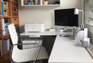 A printer and laptop connected and working smoothly on a home office desk.