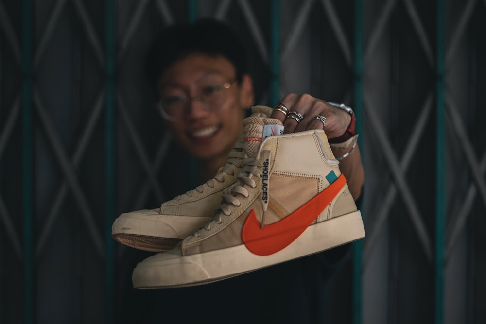 man in black shirt holding brown and white nike air force 1 high