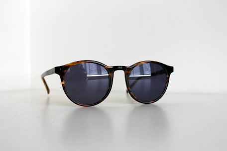 black framed sunglasses on white table