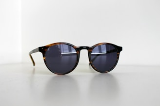 black framed sunglasses on white table