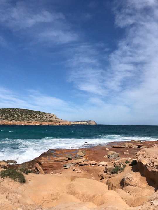 brown rocky shore under blue sky during daytime in Illa des bosc Spain