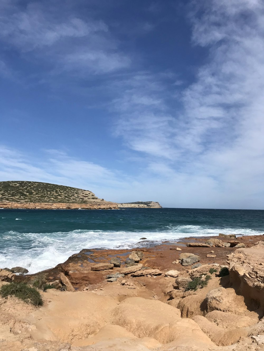 brown rocky shore under blue sky during daytime