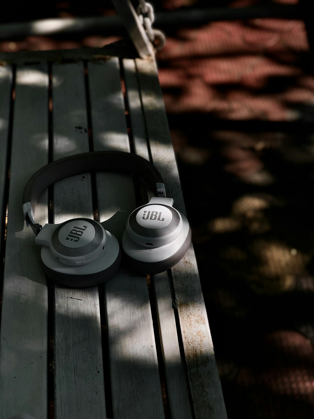 white sony headphones on black wooden bench