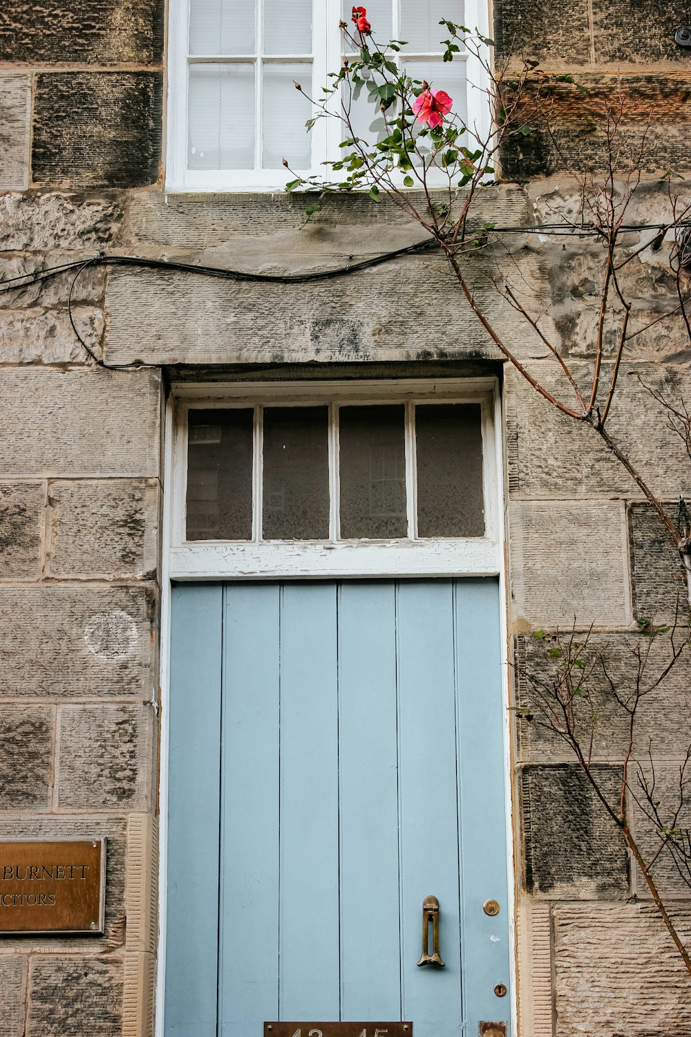 ventana de madera azul sobre pared de hormigón marrón