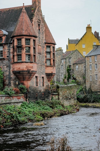 brown brick building beside river