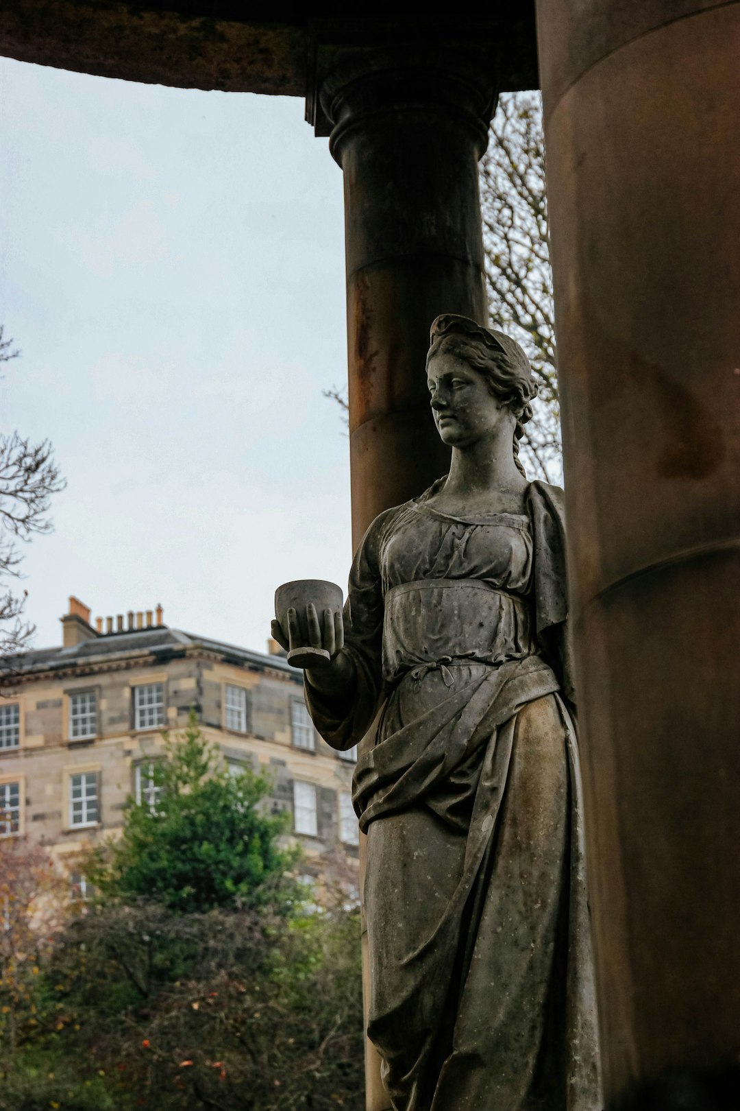 man holding book statue near brown concrete building during daytime