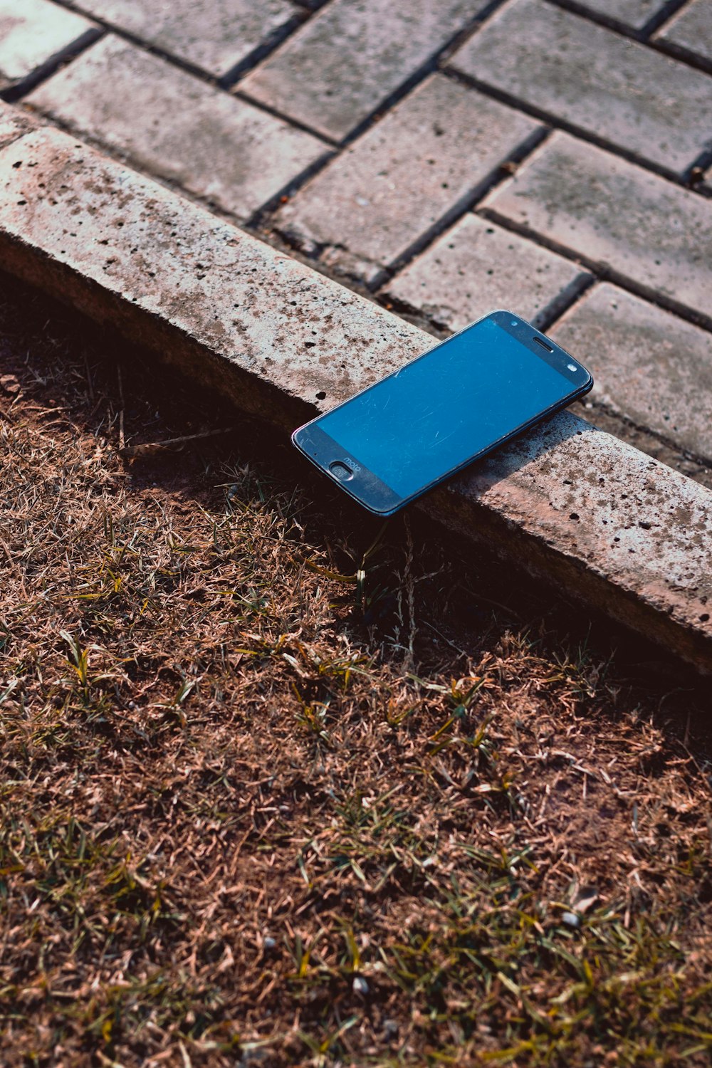 茶色の木製のベンチに青いスマートフォン