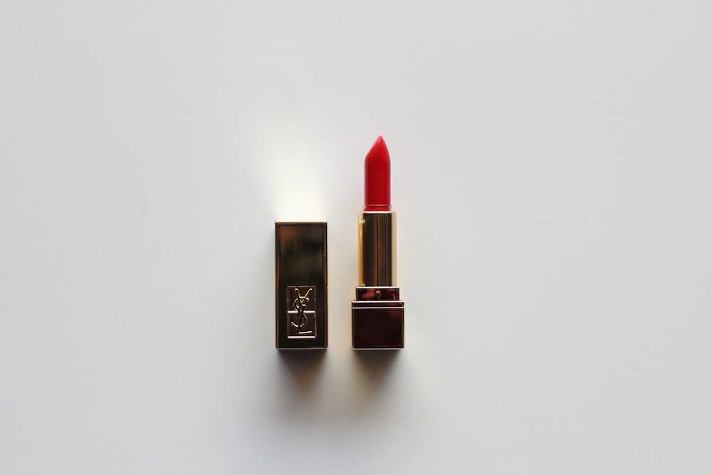 lápiz labial rojo sobre mesa blanca