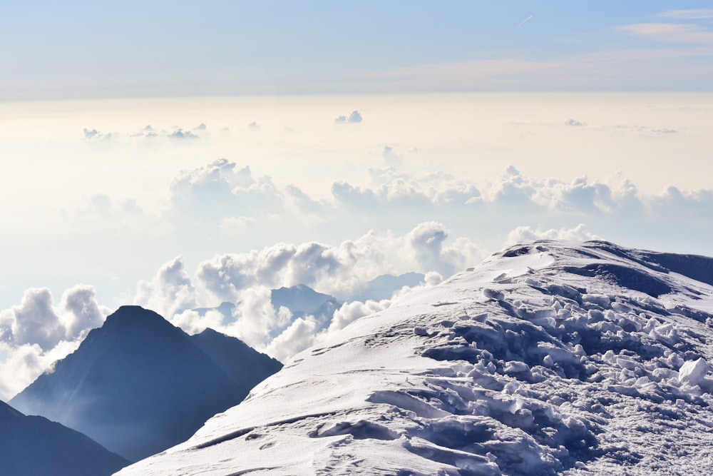 white clouds over snow covered mountain during daytime