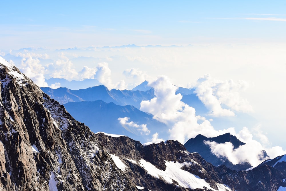 snow covered mountain under white clouds and blue sky during daytime