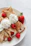 Close-up of a delicious crepe filled with fresh strawberries and cream on a rustic wooden table.